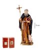 Figura de santo con una cruz en la mano derecha y un libro en la mano izquierda va vestido de marron y negro es anciano y tiene barba y pelo gris y a sus pies hay un cerdo pequeño de color rosa