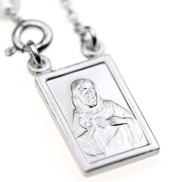 escapulario plateado con cadena y mosqueton y medalla de forma rectangular con imagen de jesucristo en busto señalando su corazon en llamas